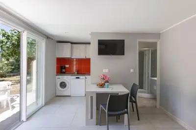 a kitchen with a table and chairs and a sink at Village de Vacances Marina d'Oru in Ghisonaccia