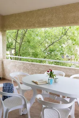 a white table and chairs in front of a window at Village de Vacances Marina d'Oru in Ghisonaccia