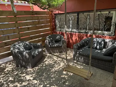 a patio with red chairs and a table and a tree at Chambres d'Hôtes Terra Bella in Lecci