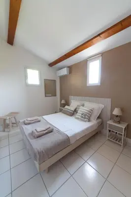 a bedroom with a large bed and two windows at Vista Mare in Porticcio