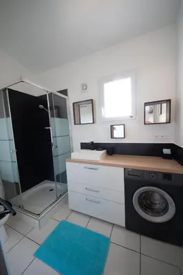 a bathroom with a sink and a washing machine at Vista Mare in Porticcio