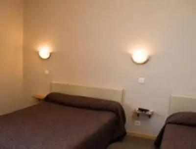 a room with two beds and two lights on the wall at Les Orangers in Aléria