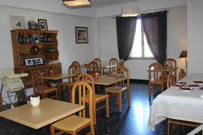 a dining room with wooden tables and chairs at Les Orangers in Aléria