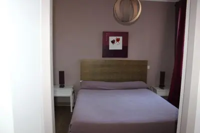 a bedroom with a bed and two tables and a mirror at Les Orangers in Aléria