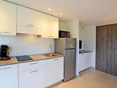 a kitchen with white cabinets and a stainless steel refrigerator at Apartment MB6 Loggia by Interhome in Moriani Plage