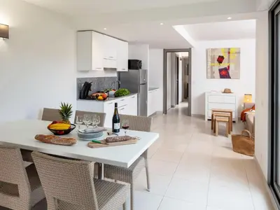 a kitchen and living room with a white table and chairs at Apartment MB6 Loggia by Interhome in Moriani Plage