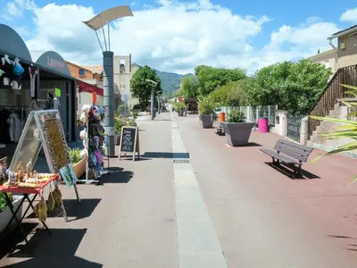 a street with tables and benches on a sidewalk at Apartment MB6 Loggia by Interhome in Moriani Plage