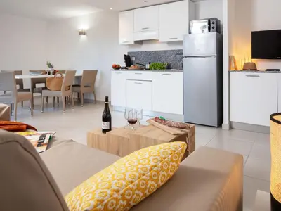a kitchen and a living room with a bottle of wine at Apartment MB6 Loggia by Interhome in Moriani Plage
