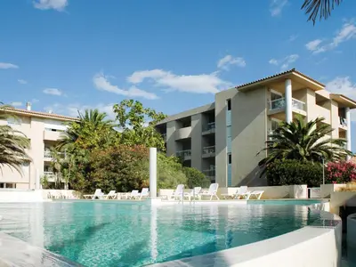a large blue swimming pool with trees and the ocean at Apartment MB4 Loggia by Interhome in Moriani Plage
