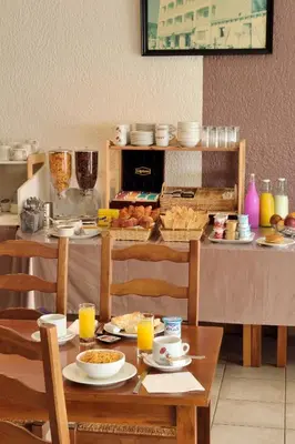 a table with plates of food and orange juice at Hotel Alata in Alata