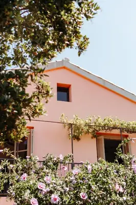 a pink house with flowers in front of it at U Parasu in Santa-Maria-Figaniella