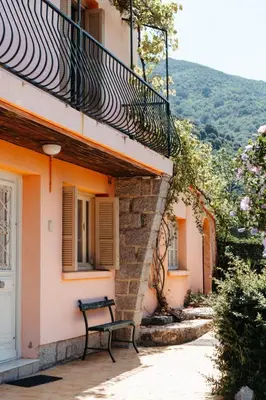a bench sitting outside of a building with a balcony at U Parasu in Santa-Maria-Figaniella