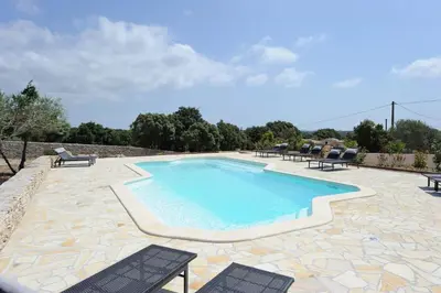a swimming pool with two chairs and a table at CHALET CANAVA in Bonifacio