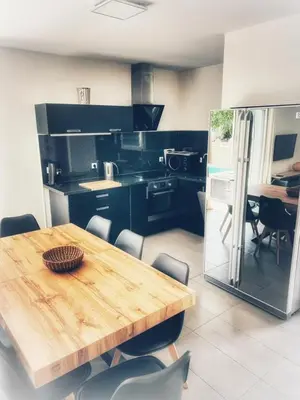 a kitchen with a wooden table and some chairs at Villa Orethaga Piscine 10 pers porto Vecchio in Porto-Vecchio