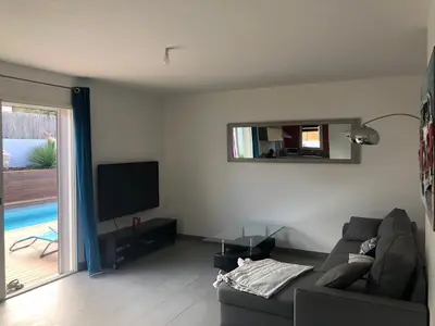 a living room with a couch and a flat screen tv at Villa Orethaga Piscine 10 pers porto Vecchio in Porto-Vecchio