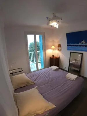 a bedroom with a large bed and a window at LA TERRASSE DE SAINT-JEAN in Ajaccio