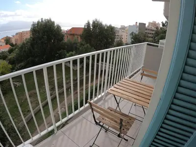 a balcony with a bench and a view of the ocean at LA TERRASSE DE SAINT-JEAN in Ajaccio