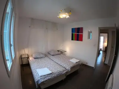 a bedroom with a bed and a painting on the wall at LA TERRASSE DE SAINT-JEAN in Ajaccio