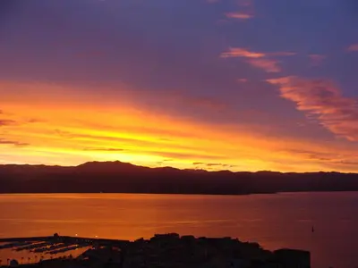 a sunset over the water with a city at LA TERRASSE DE SAINT-JEAN in Ajaccio