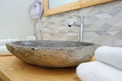 a stone sink on a counter in a bathroom at Hotel Le Tourisme in Zonza