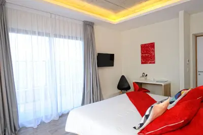 a bedroom with a bed and a large window at Hotel Le Tourisme in Zonza