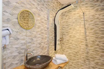 a bathroom with a sink and a shower at Hotel Le Tourisme in Zonza