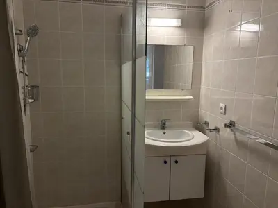 a bathroom with a sink and a mirror at PALMERAIE 220 in Sari Solenzara