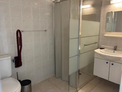 a bathroom with a shower and a toilet and a sink at PALMERAIE 220 in Sari Solenzara