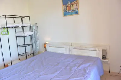 a bedroom with a bed with a blue comforter at PALMERAIE 325 in Sari Solenzara