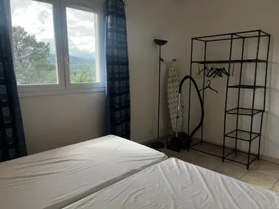 a bedroom with a white bed and a window at PALMERAIE 325 in Sari Solenzara