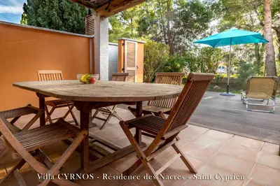 a wooden table with chairs and an umbrella on a patio at CYRNOS in Porto-Vecchio