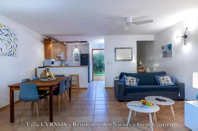 a living room with a blue couch and a table at CYRNOS in Porto-Vecchio