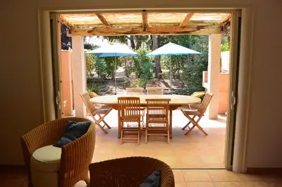 a patio with a table and chairs and umbrellas at CYRNOS in Porto-Vecchio