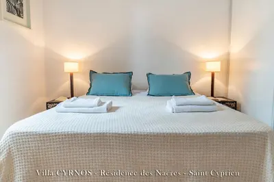 a bedroom with a large bed with blue pillows at CYRNOS in Porto-Vecchio