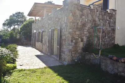 a stone wall next to a house at FIUMICELLI in Sari Solenzara