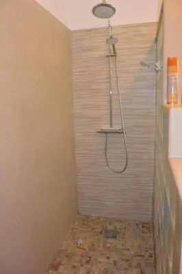 a shower in a bathroom with a tile floor at FIUMICELLI in Sari Solenzara