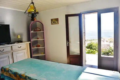 a room with a table and a view of the ocean at FIUMICELLI in Sari Solenzara