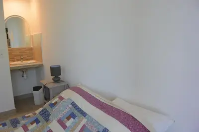 a bedroom with a bed with a sink and a mirror at FIUMICELLI in Sari Solenzara