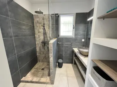 a bathroom with a shower and a sink at SOLEIL ROUGE in Sari Solenzara