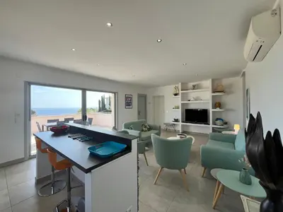 a kitchen and living room with a view of the ocean at SOLEIL ROUGE in Sari Solenzara