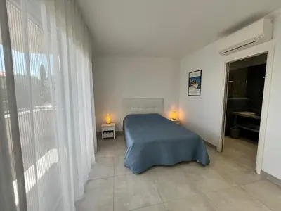 a bedroom with a bed and two lamps in it at SOLEIL ROUGE in Sari Solenzara