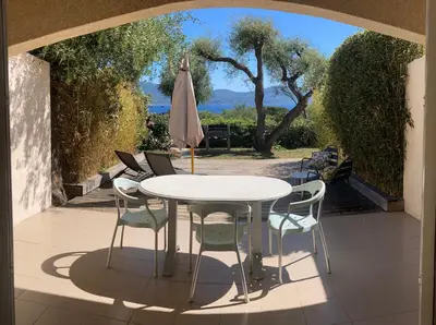 a table and chairs and an umbrella on a patio at Résidence Ogliastrello in Olmeto