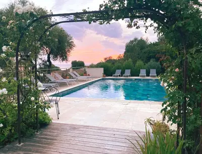 a swimming pool with chairs and an archway at Résidence Ogliastrello in Olmeto