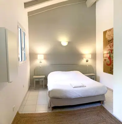 a bedroom with a white bed and two lamps at Résidence Ogliastrello in Olmeto