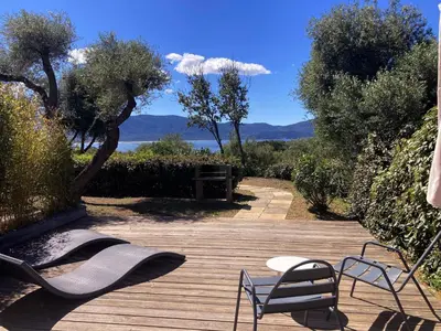 a deck with two chairs and a table and chairs at Résidence Ogliastrello in Olmeto