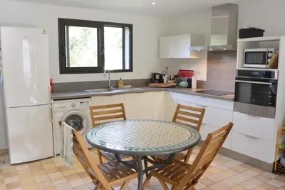 a kitchen with a table and chairs in a kitchen at FILETTA in Sari Solenzara