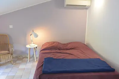 a bed in a room with a lamp and a table at FILETTA in Sari Solenzara