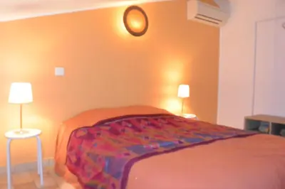 a bedroom with a bed with two lamps on the wall at FILETTA in Sari Solenzara