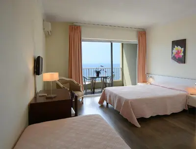 a hotel room with a bed and a view of the ocean at Sun Beach in Ajaccio