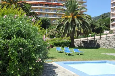 a group of blue lounge chairs next to a building at Sun Beach in Ajaccio